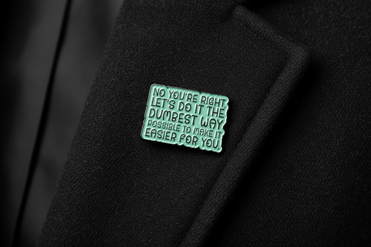 Green metal badge with text on a black fabric background