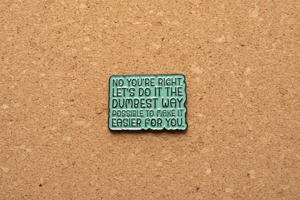 Green metal badge with text on a cork background
