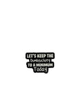 Black and white enamel pin with text on a gray background