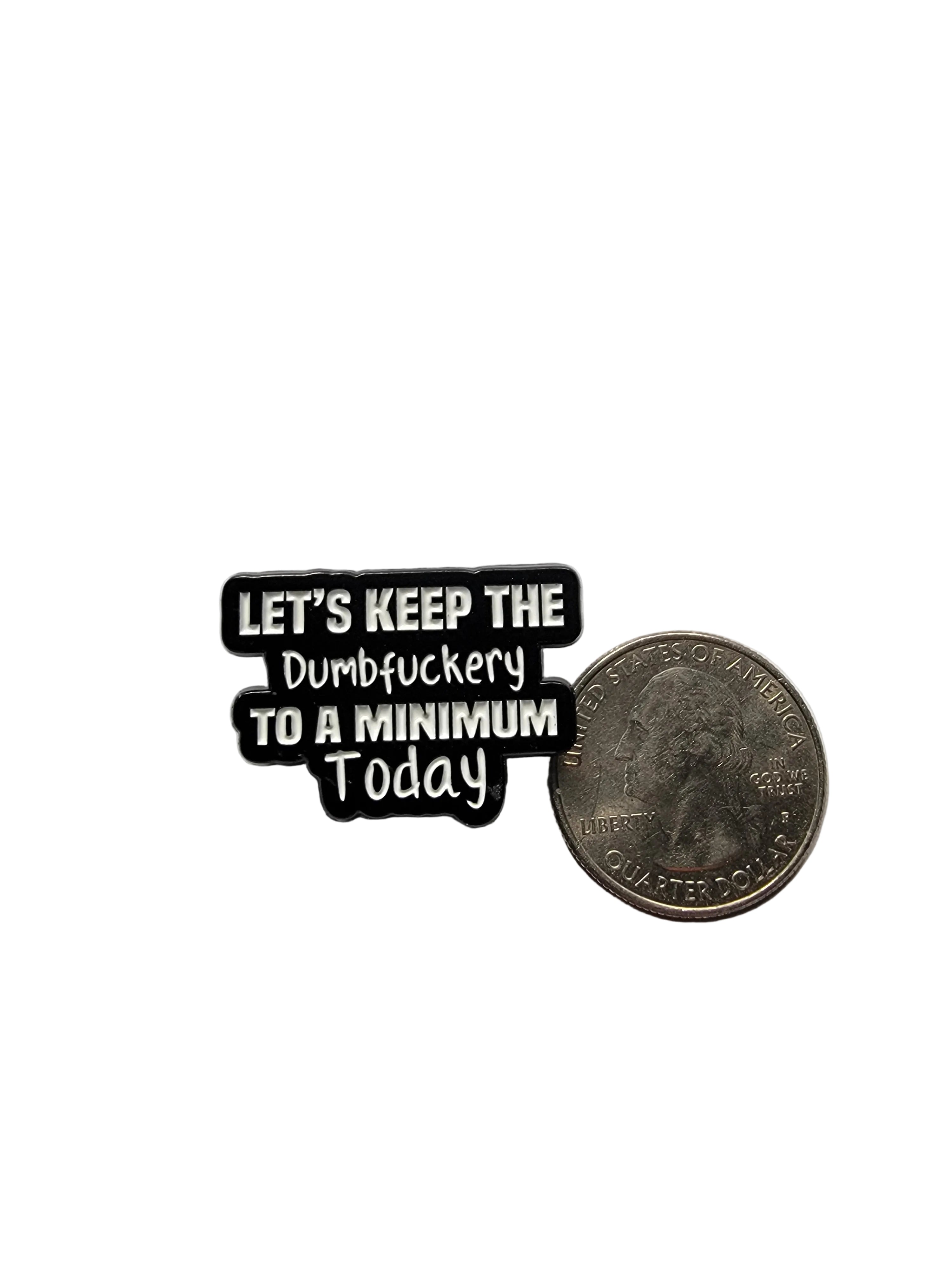 Black and white text magnet on a gray surface with a quarter for scale