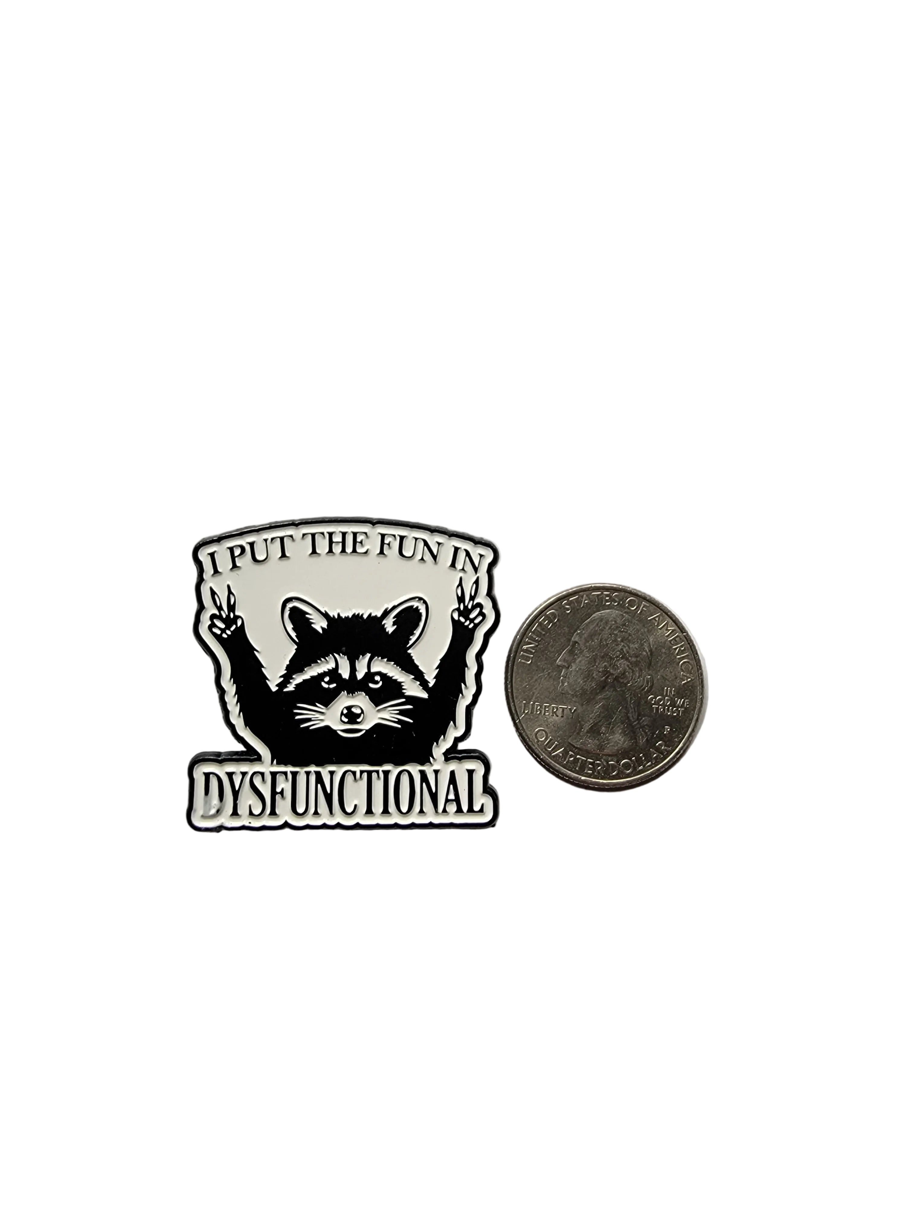 Pin with a raccoon design and text next to a quarter on a gray background