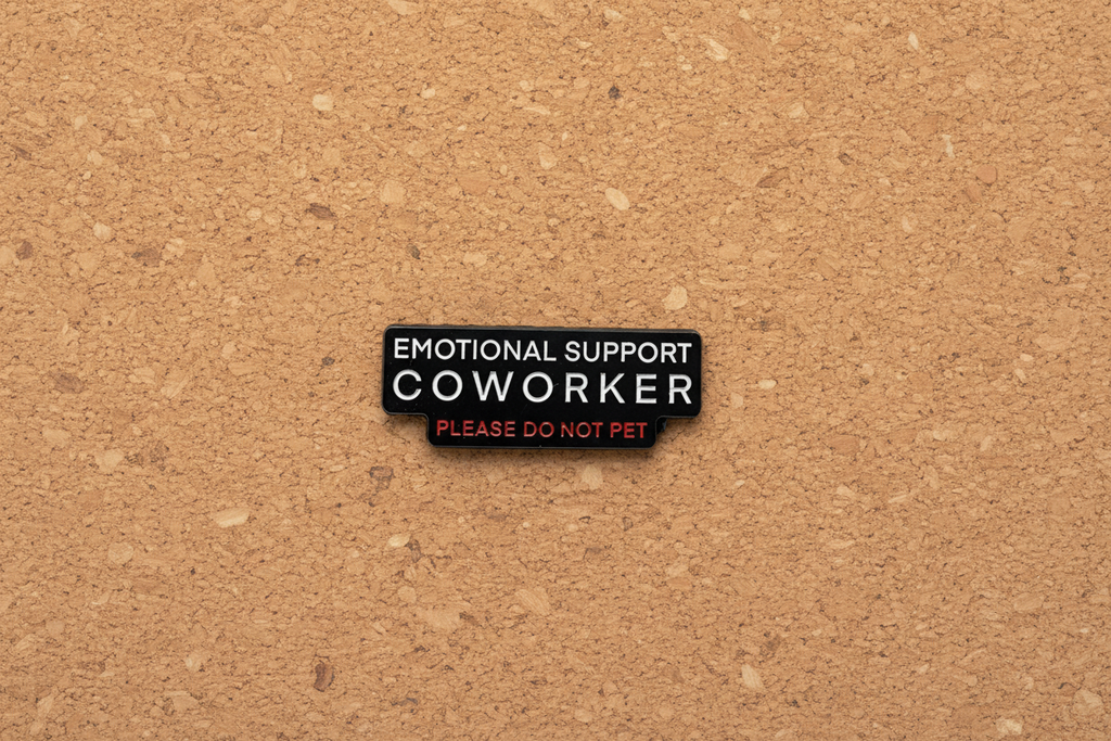 Black pin with white and red writing on a cork background