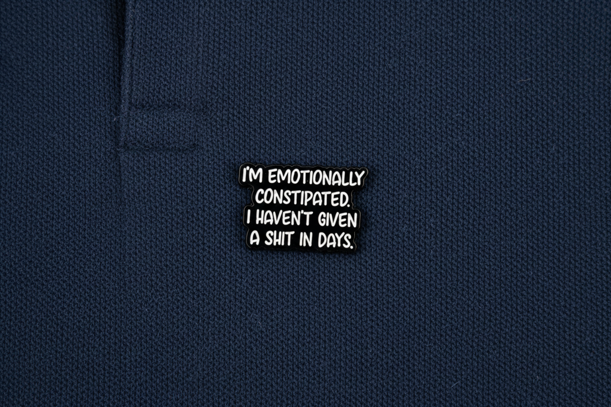Black metal badge with text on a blue fabric background