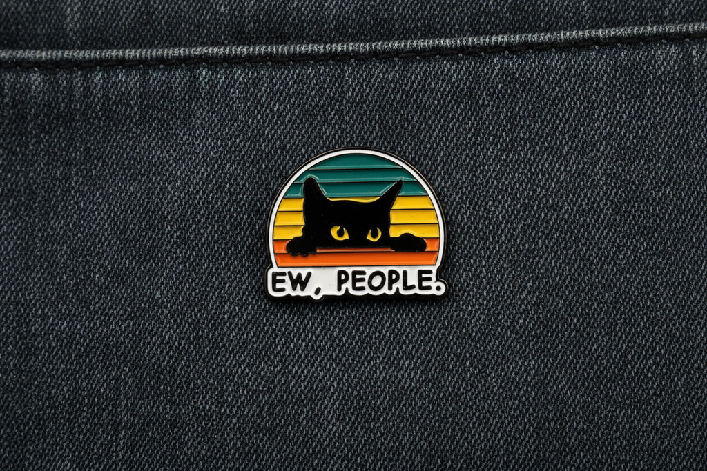 Pin with a black cat design and 'EW. PEOPLE.' text on a denim background