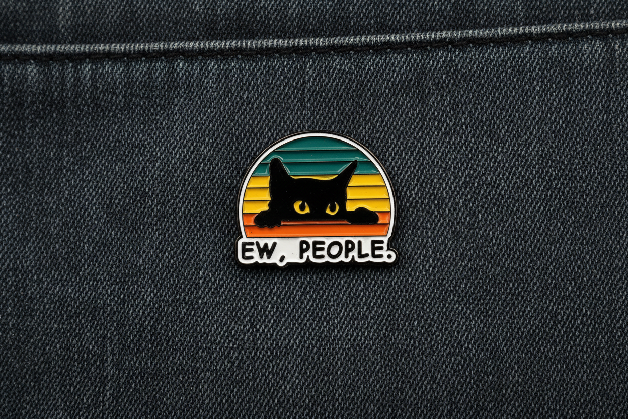 Pin with a black cat design and 'EW. PEOPLE.' text on a denim background