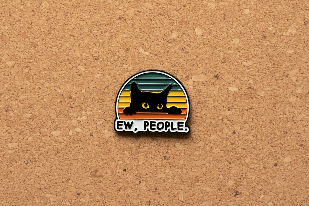 Pin with a black cat design and 'EW. PEOPLE.' text on a cork background