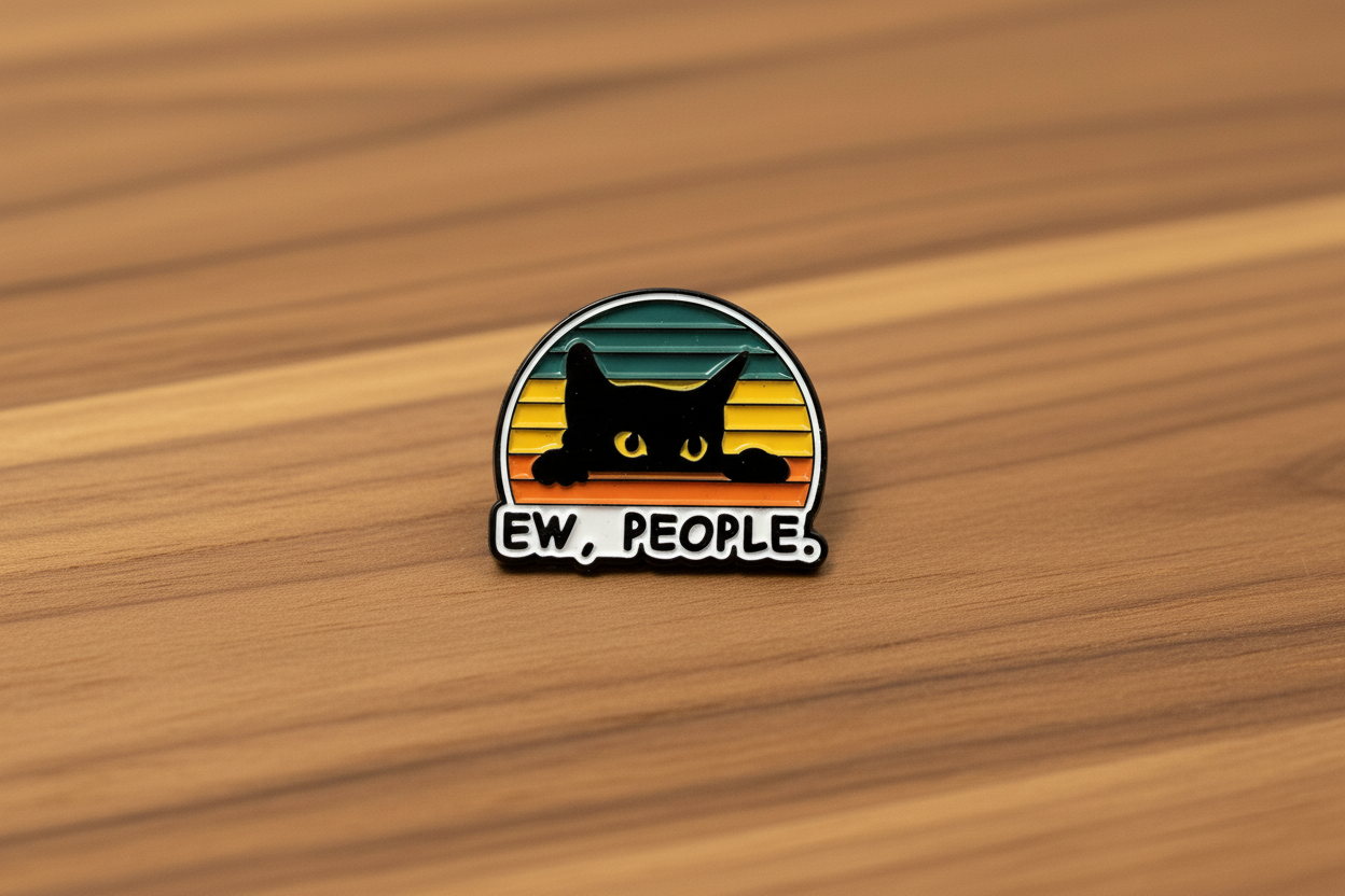 Pin with a black cat design and 'EW. PEOPLE.' text on a wood background