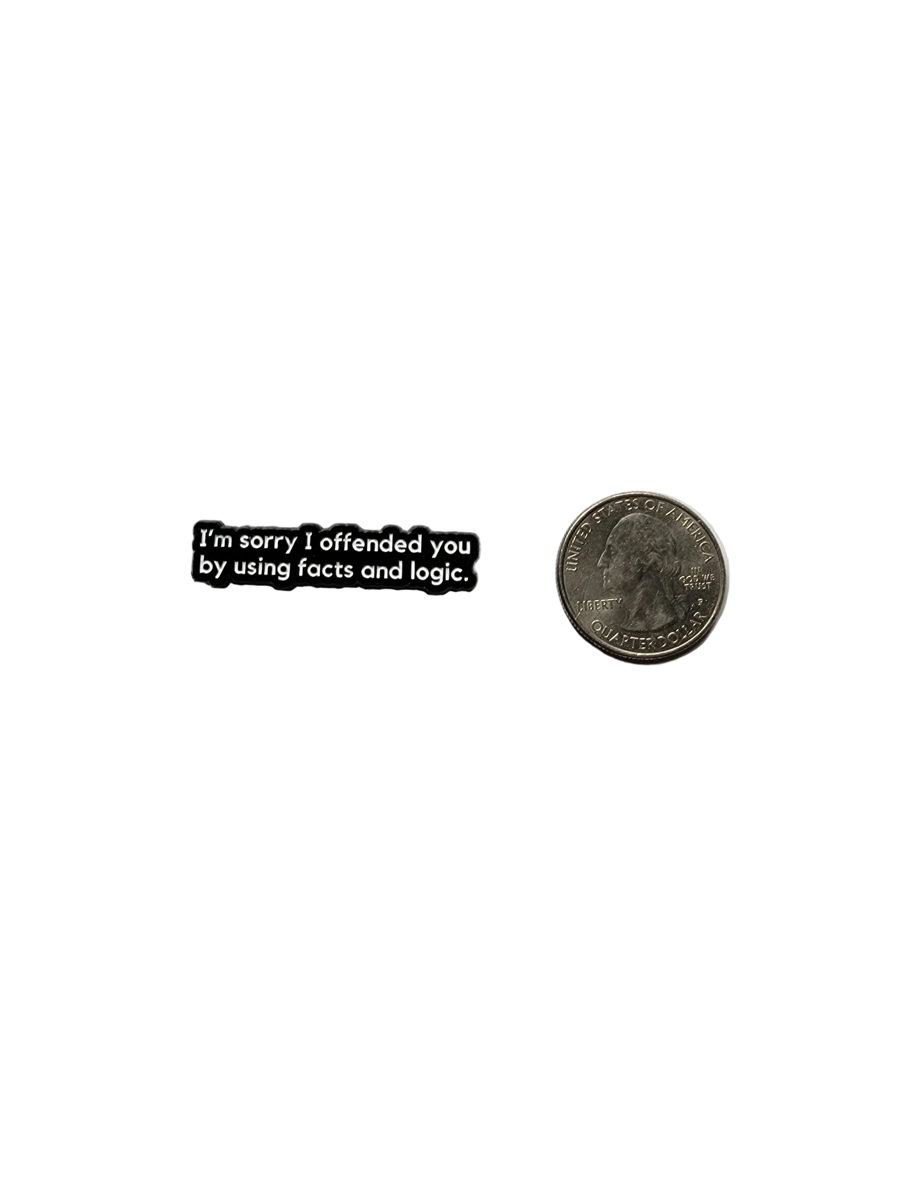 Small black rectangular object with text on a gray background, next to a quarter for scale.