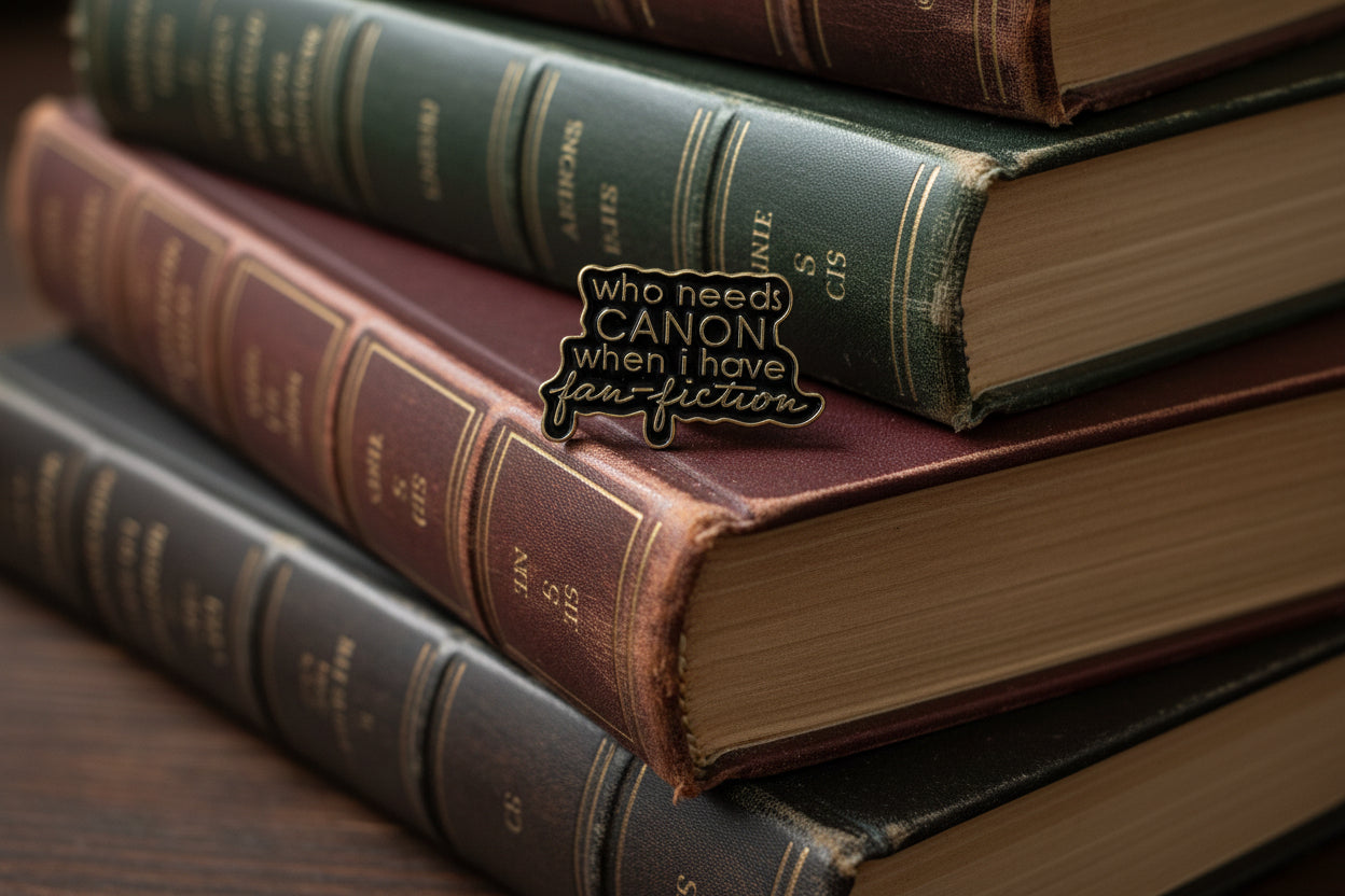 a black enamel pin with gold text on a stack of books