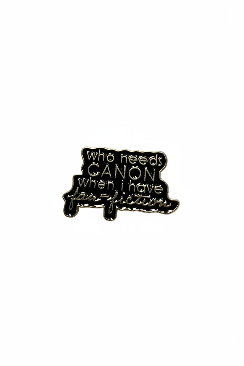 a black enamel pin with gold text on a white background