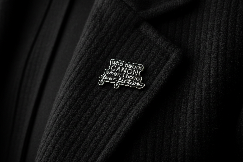 a black enamel pin with gold text on a black lapel background