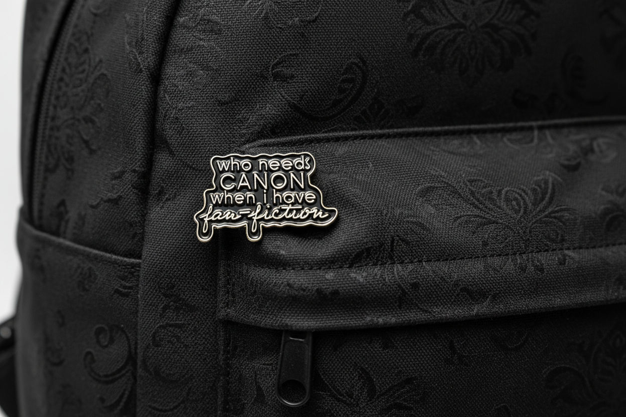 a black enamel pin with gold text on a black bookbag background