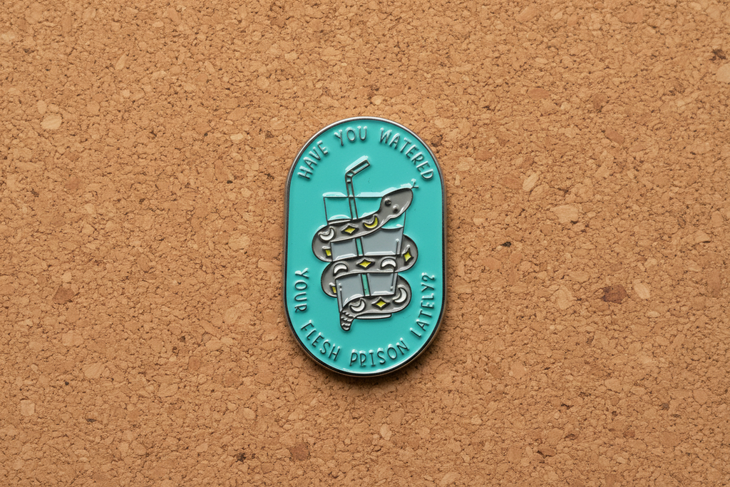 a teal pin with a snake and water on a cork background