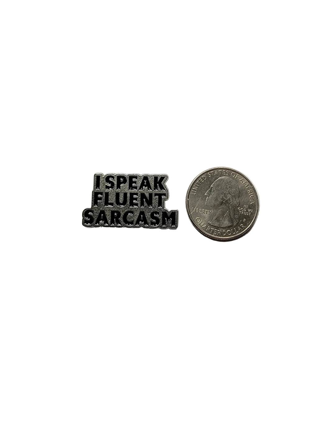 Metallic badge with 'I speak fluent sarcasm' text next to a quarter on a white background