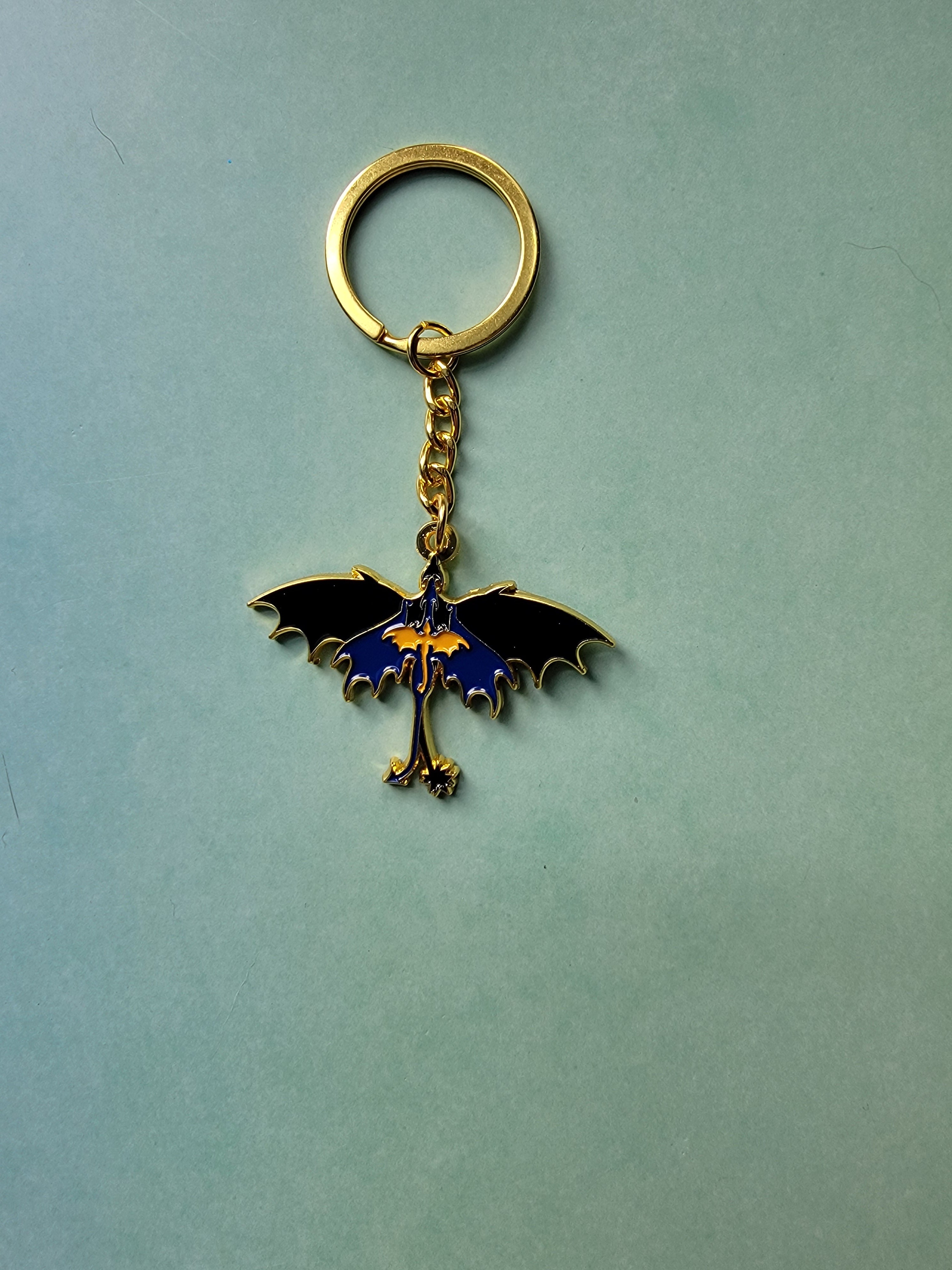 Keychain with a dragon design on a light blue background