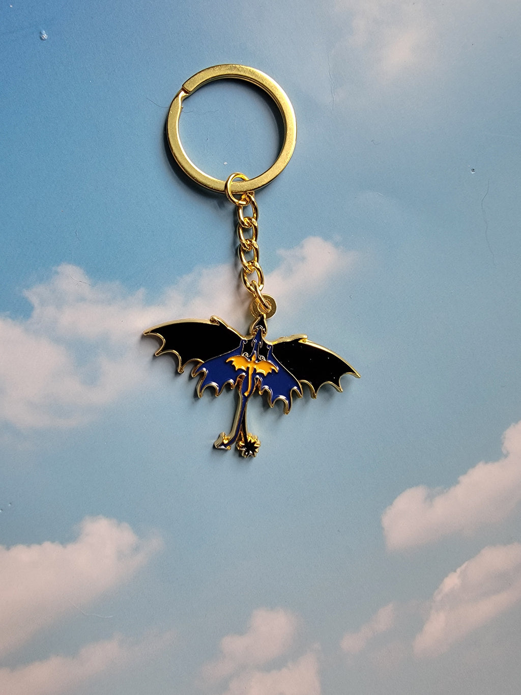 Keychain with a dragon design against a blue sky background