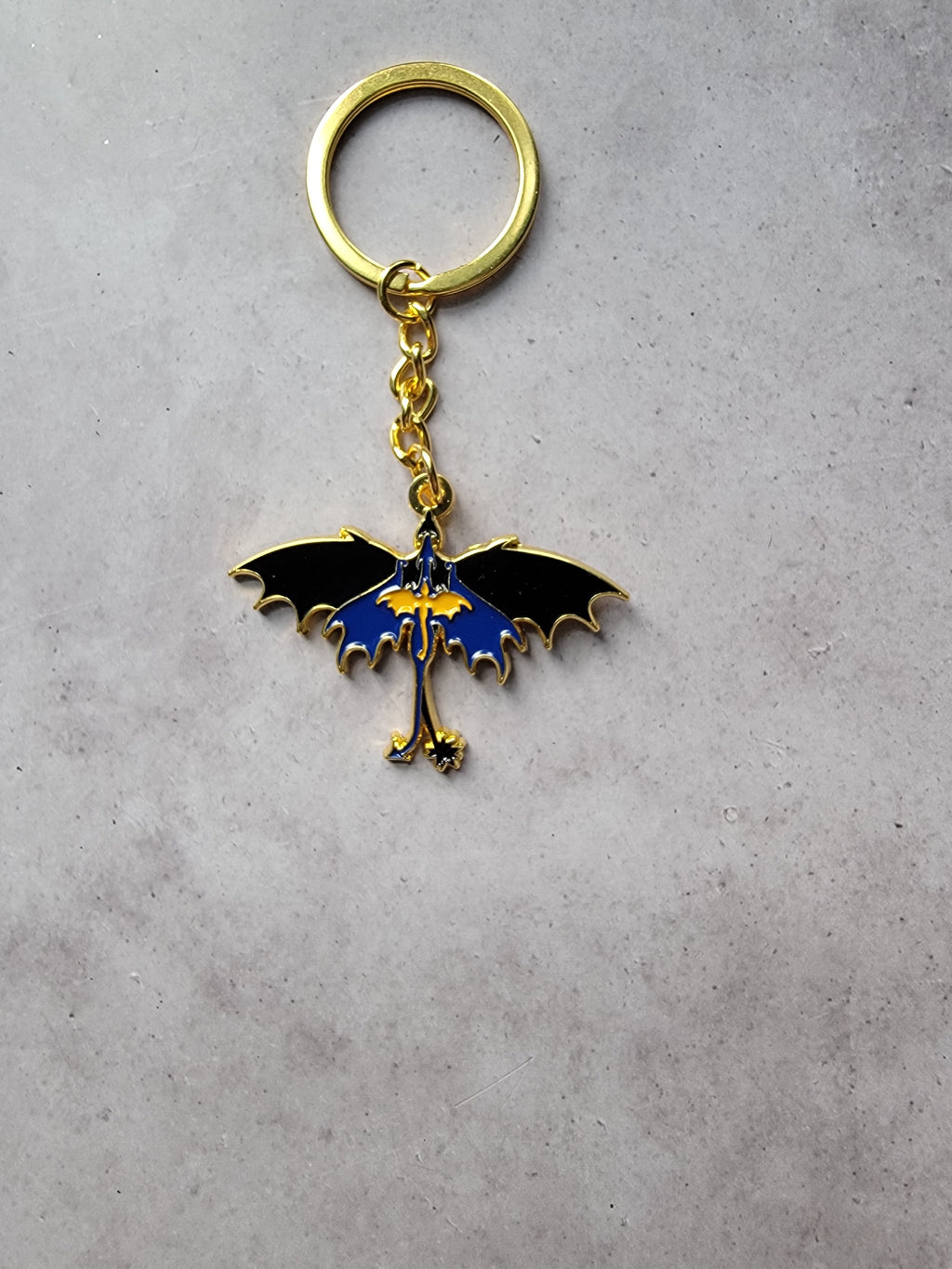 Keychain with a dragon design on a gray surface