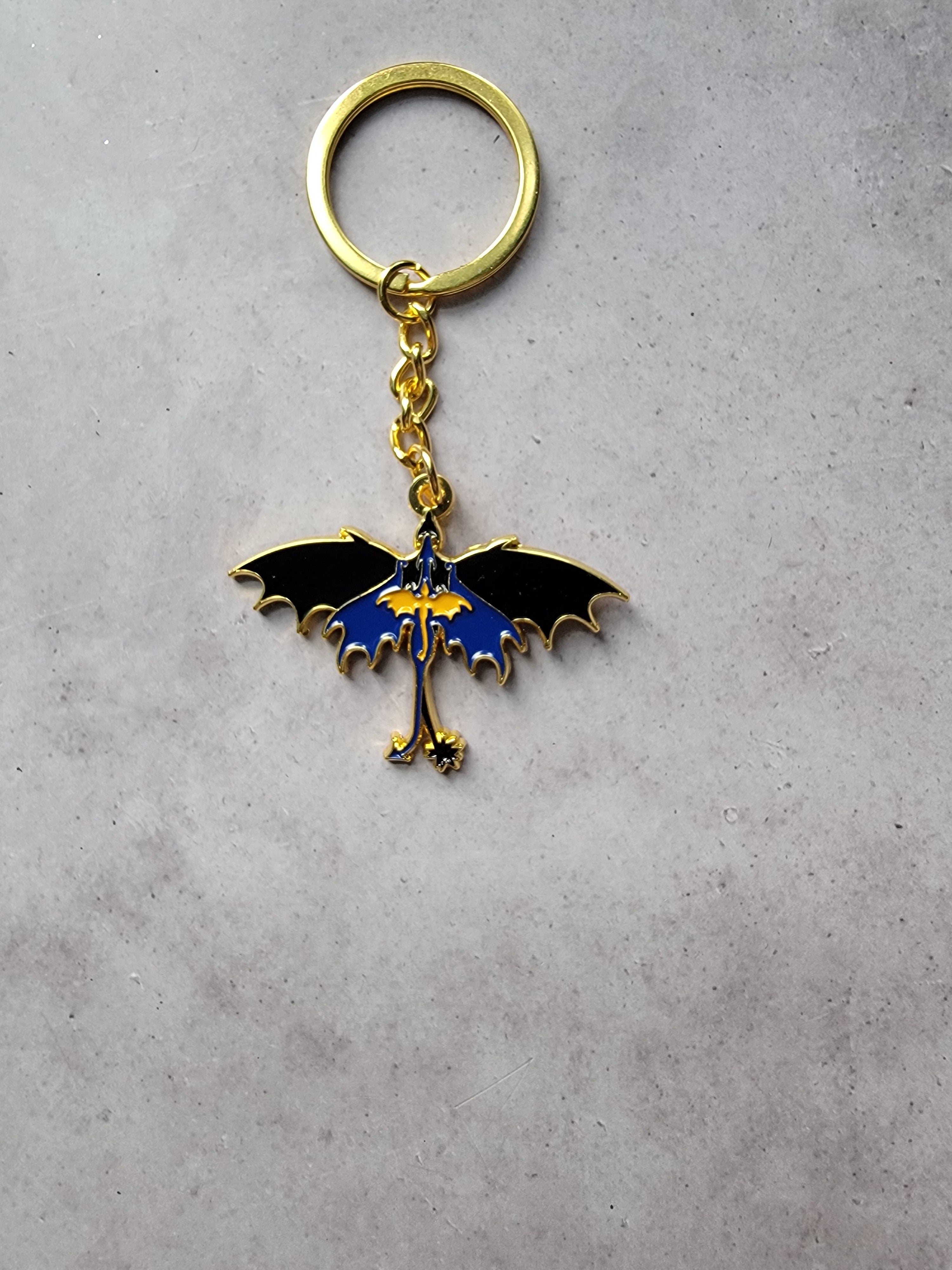 Keychain with a dragon design on a gray surface