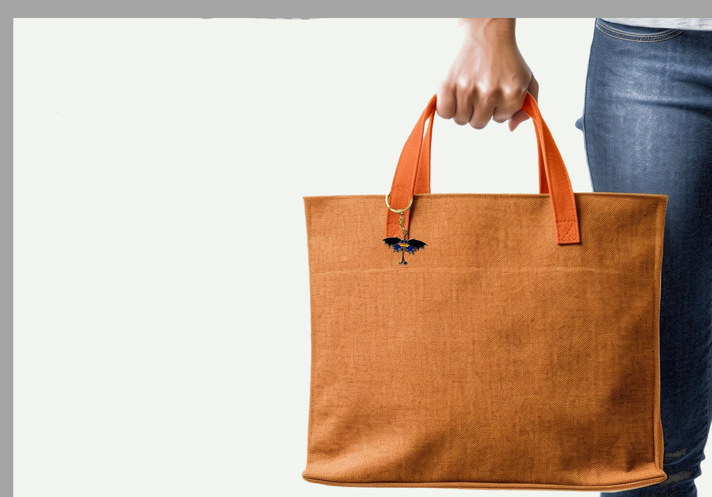 Brown tote bag with orange handles held by a person wearing blue jeans on a light gray background
