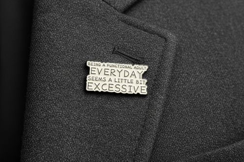 Metallic badge with text on a gray fabric lapel
