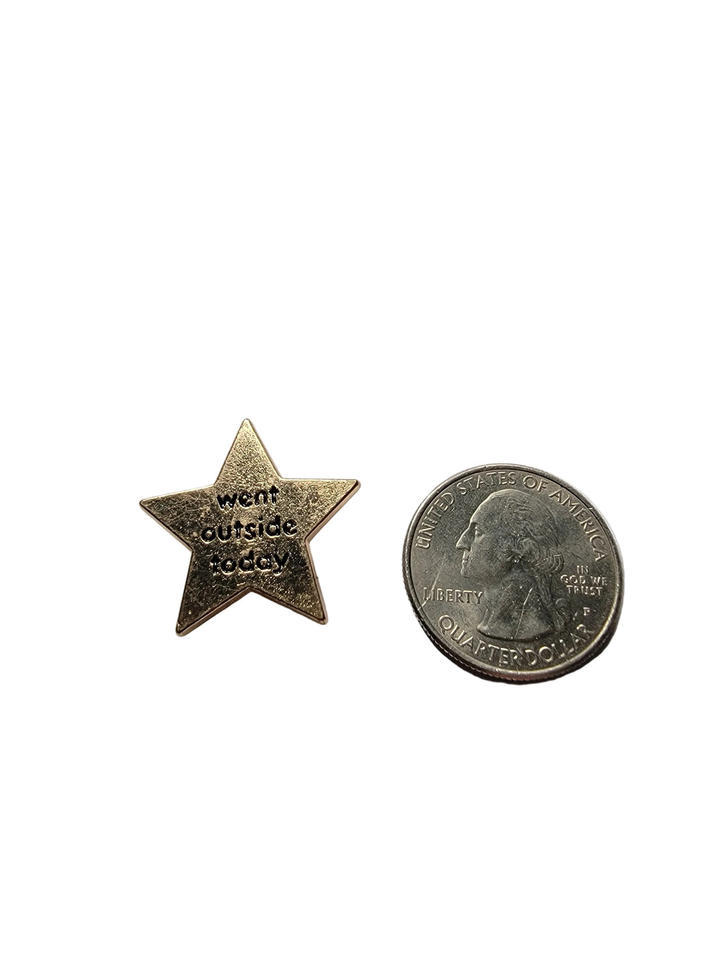 Star-shaped metal badge with engraved text next to a U.S. quarter on a light gray background