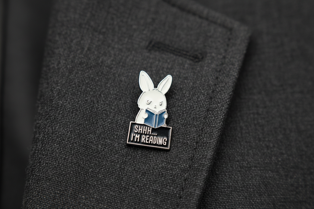 A cute bunny holding a book that says shhh i'm reading on a gray background