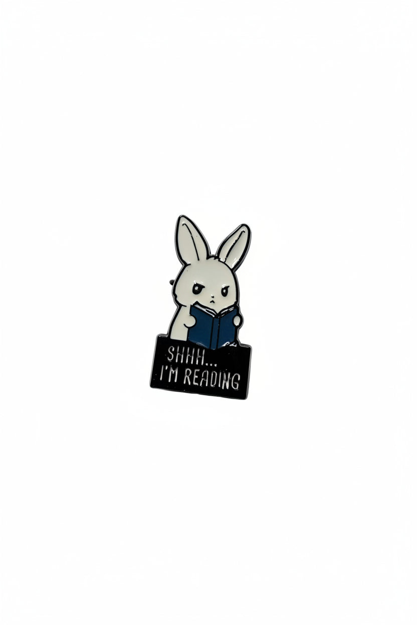 A cute bunny holding a book that says shhh i'm reading on a white background