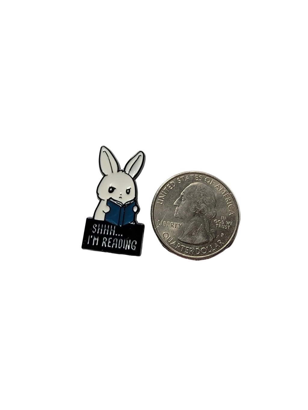 Small enamel pin with a rabbit design next to a quarter on a white background