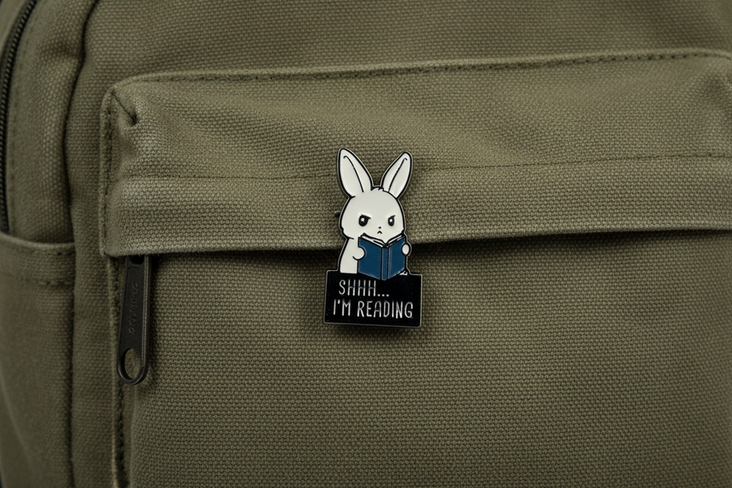 A cute bunny holding a book that says shhh i'm reading on a green fabric background