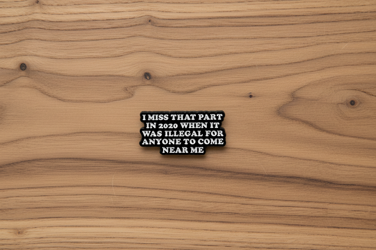 Black rectangular pin with white text on a wood background