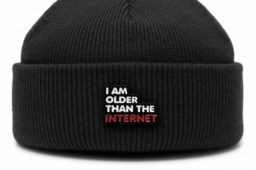 Enamel pin with 'I am older than the internet' text on a black fabric background