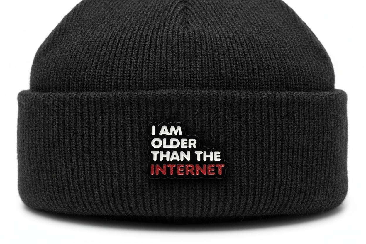 Enamel pin with 'I am older than the internet' text on a black fabric background