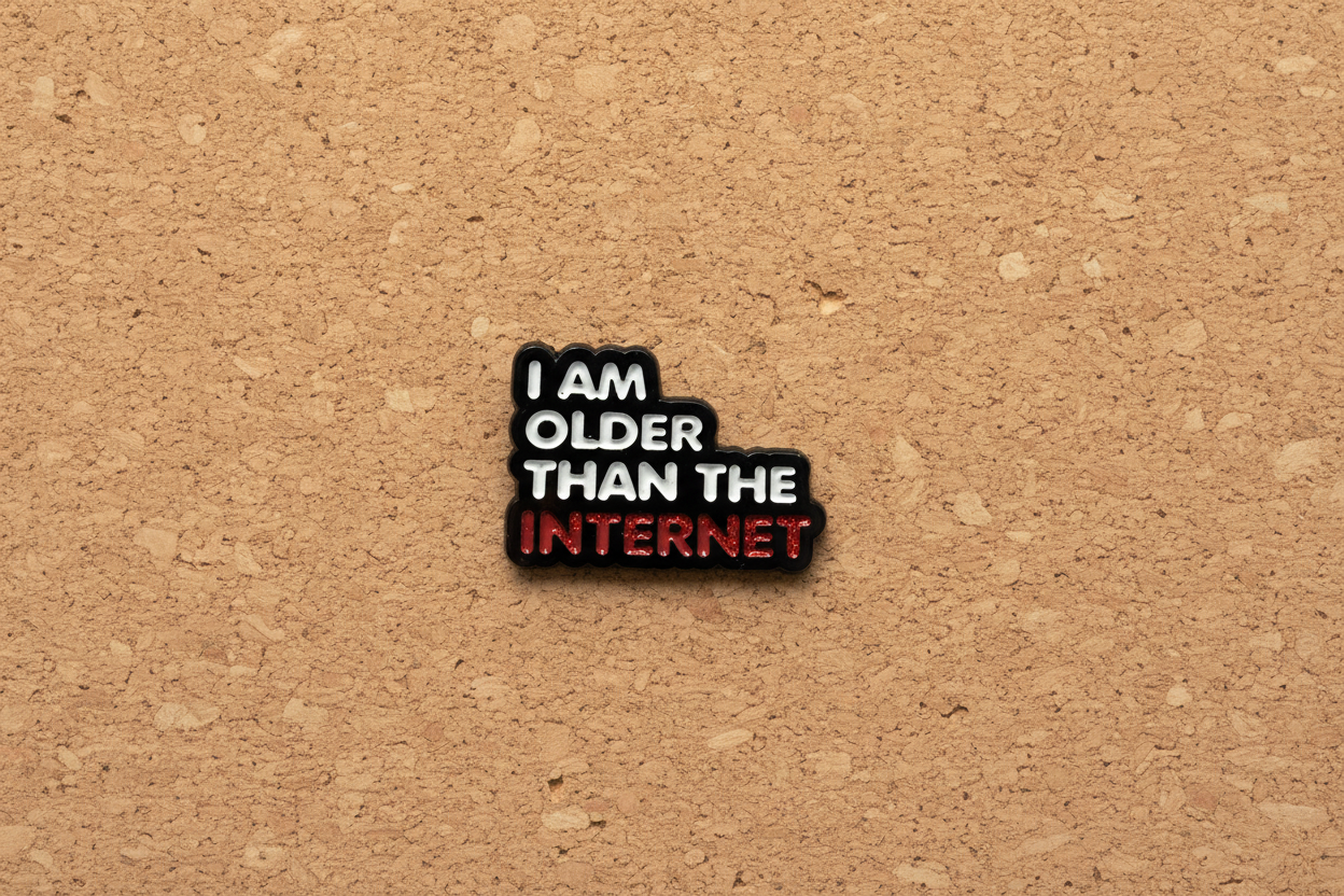 Enamel pin with 'I am older than the internet' text on a cork background