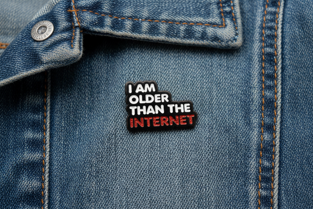 Enamel pin with 'I am older than the internet' text on a denim background