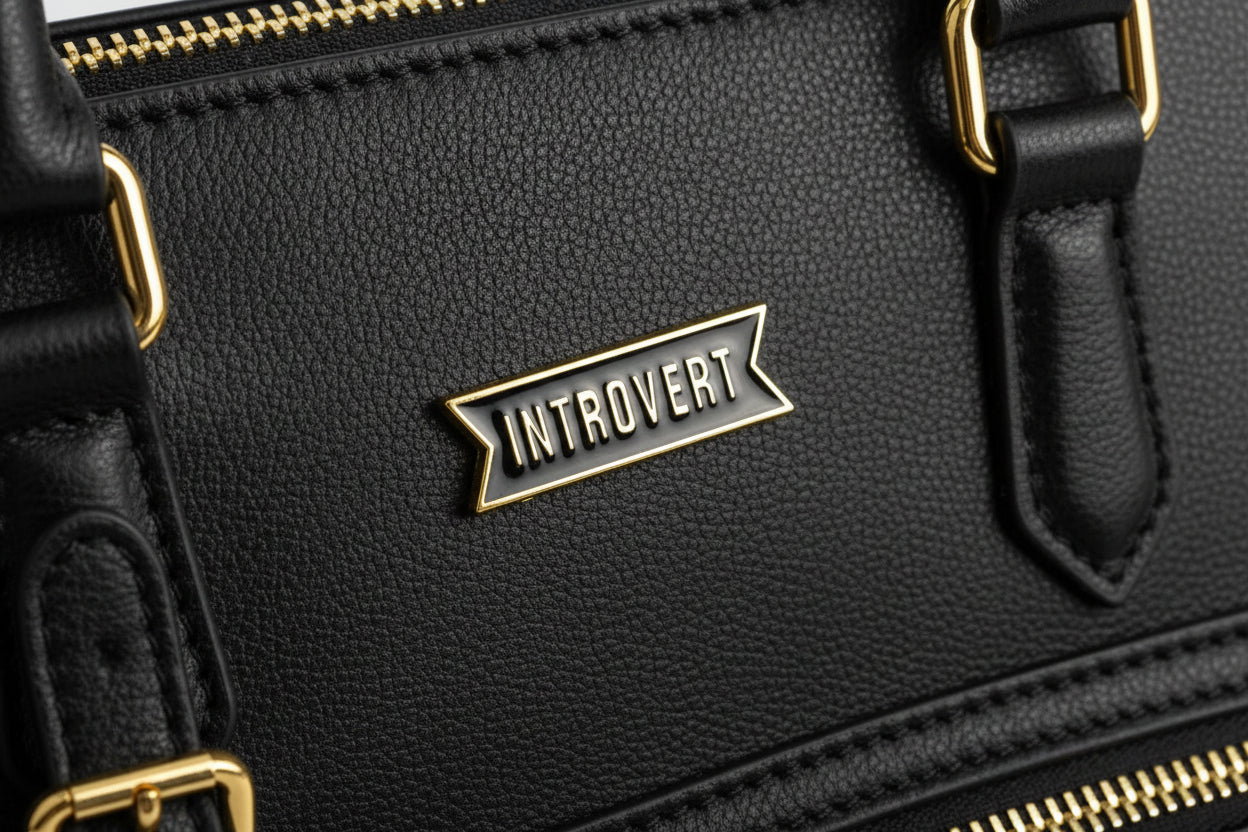 Pin with 'Introvert' text on black bookbag
