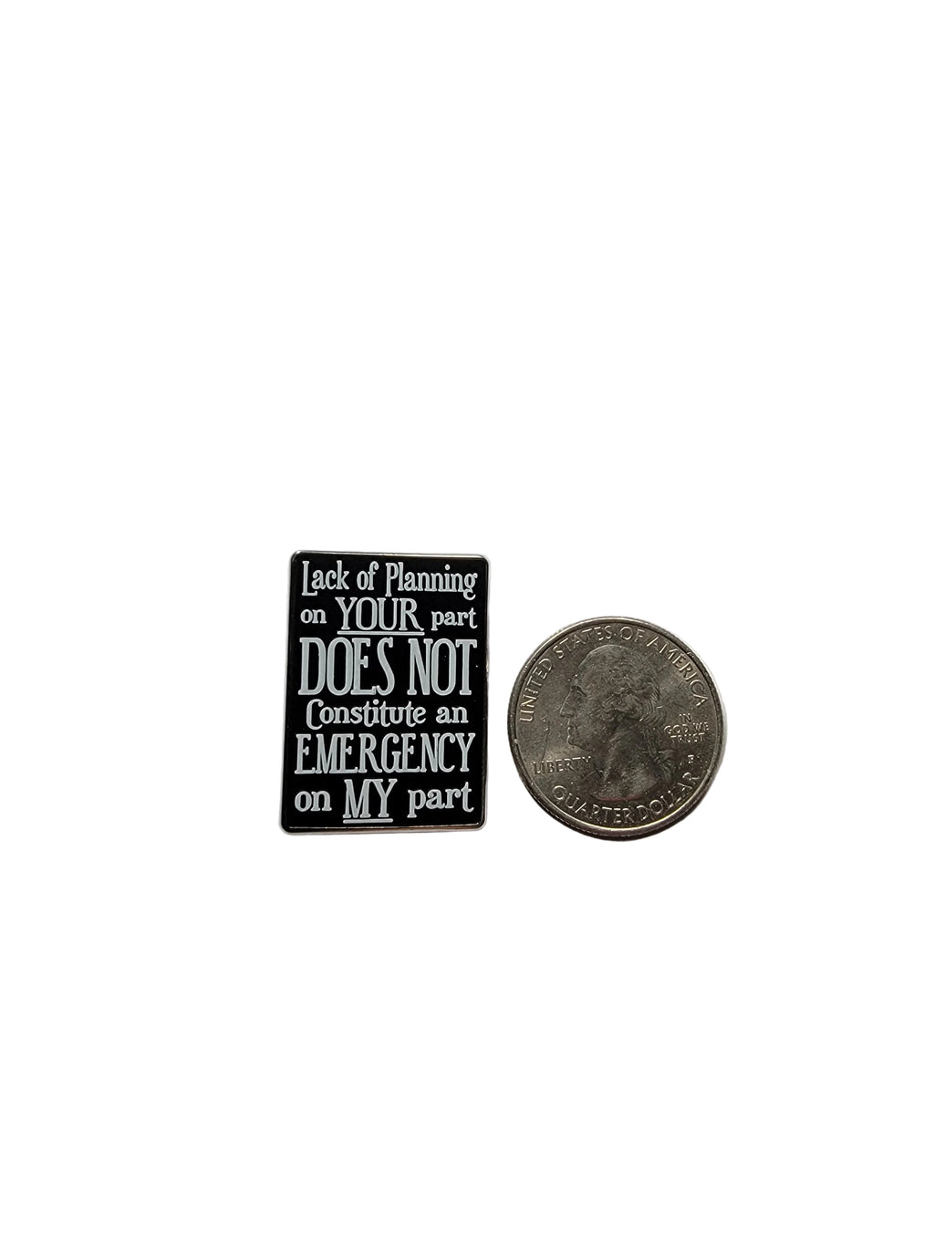 Small rectangular sign with text on a gray background, next to a quarter for scale.