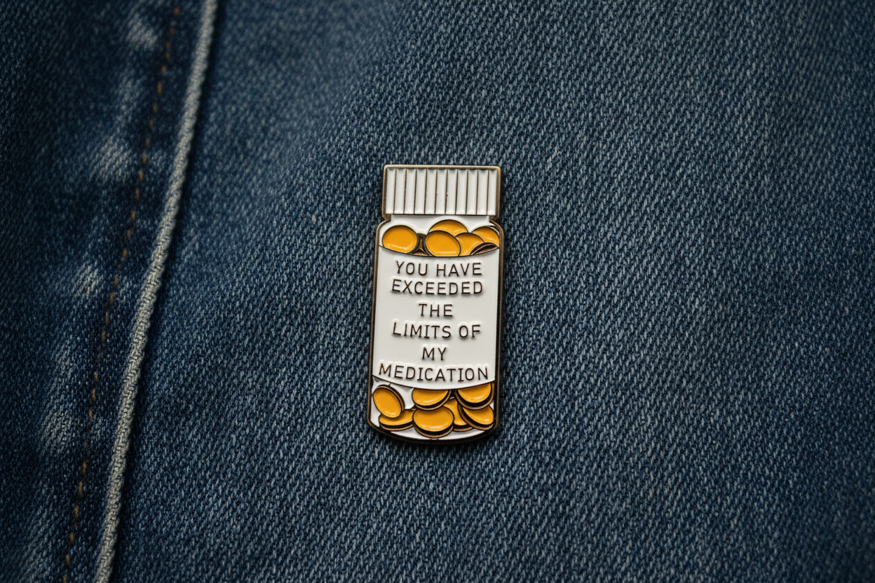 medicine bottle pin with text on a denim background