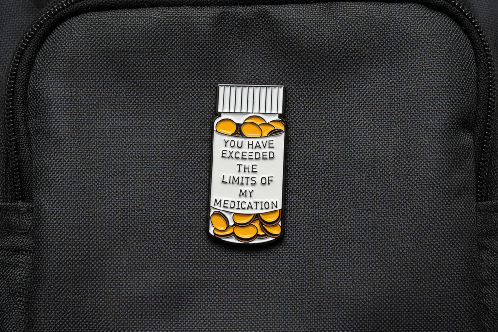 medicine bottle pin with text on a fabric background