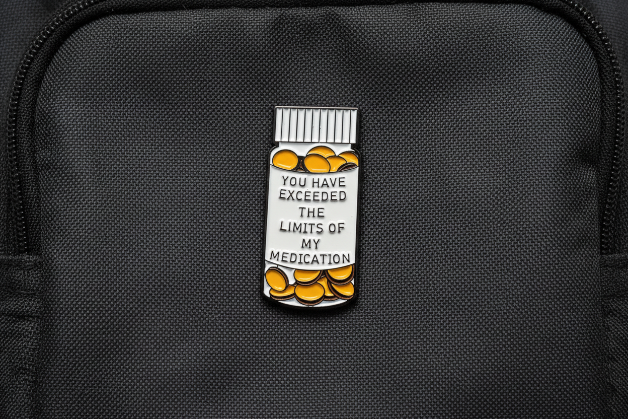 medicine bottle pin with text on a fabric background