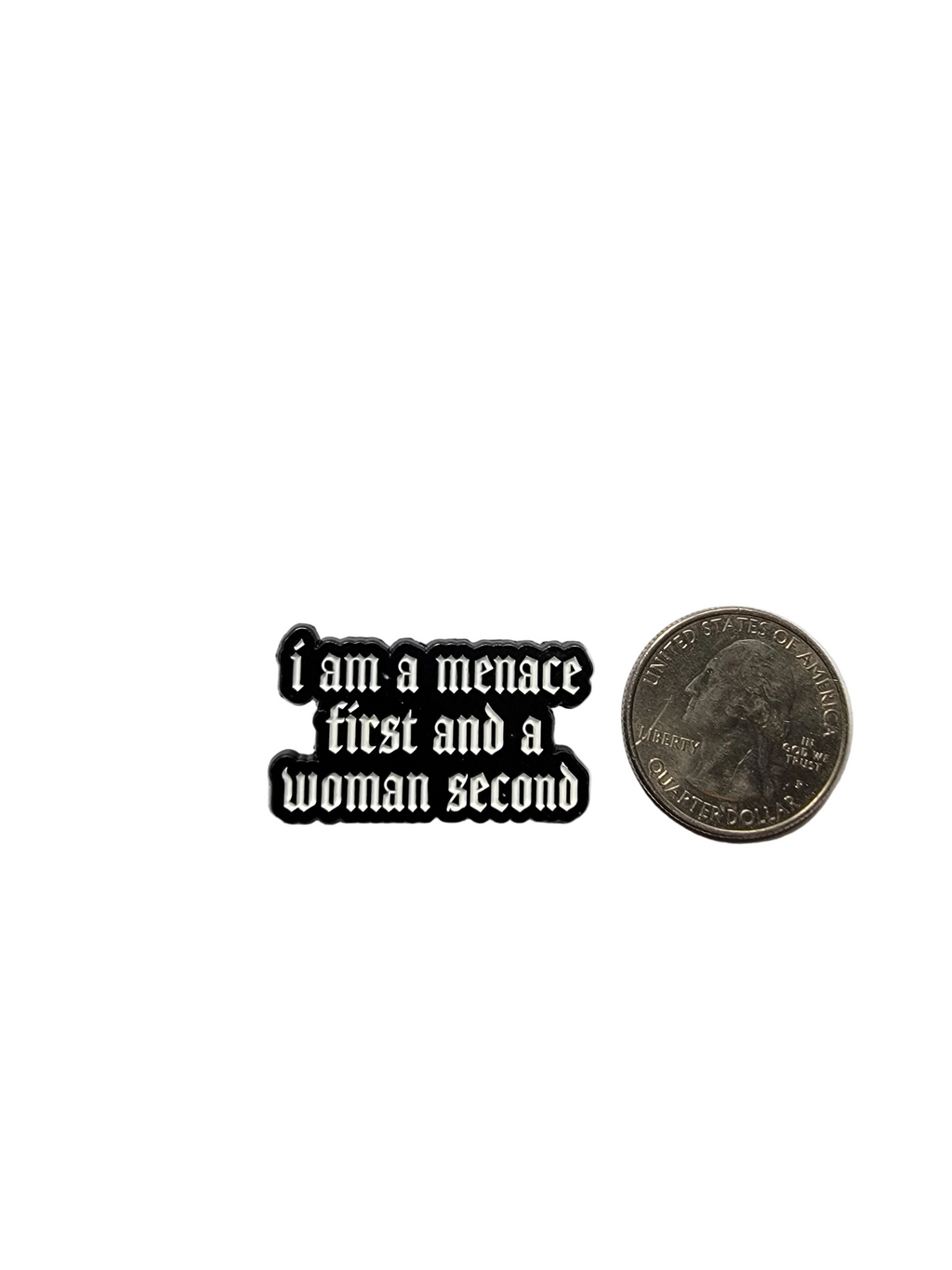 Small black and white enamel pin with text on a gray background