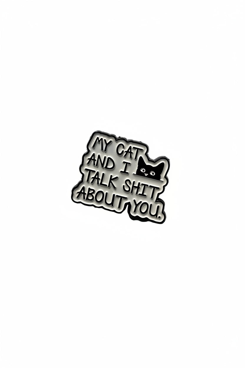 Metallic badge with text 'My cat and I talk shit about you' on a gray background