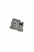 Metallic badge with text 'My cat and I talk shit about you' on a gray background
