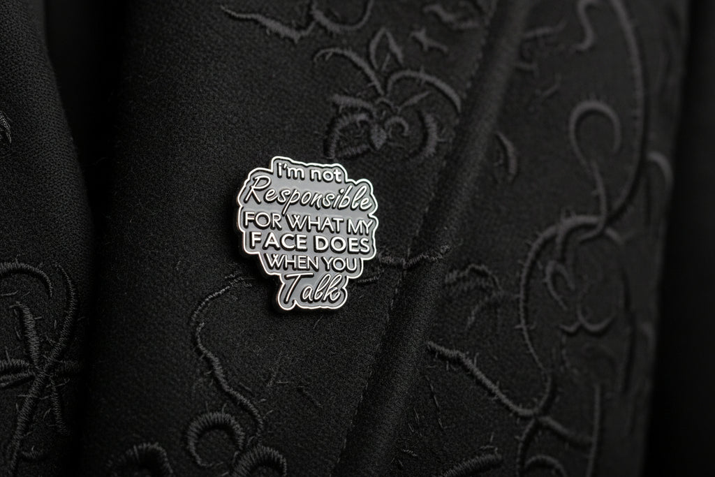 Black enamel pin with text on a white background