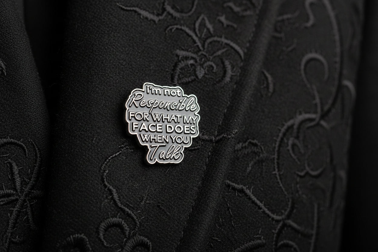 Black enamel pin with text on a white background