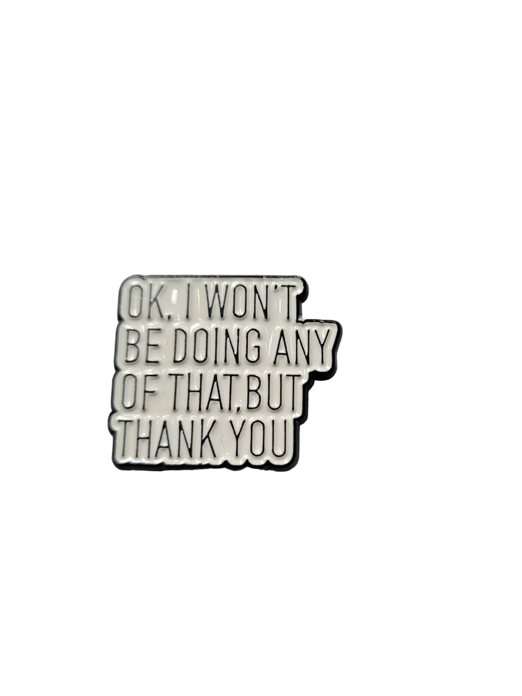 Metallic pin with text on a gray background
