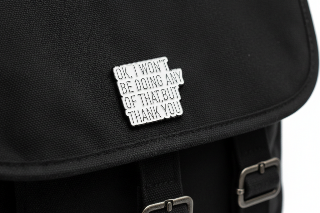 Metallic pin with text on a black fabric background