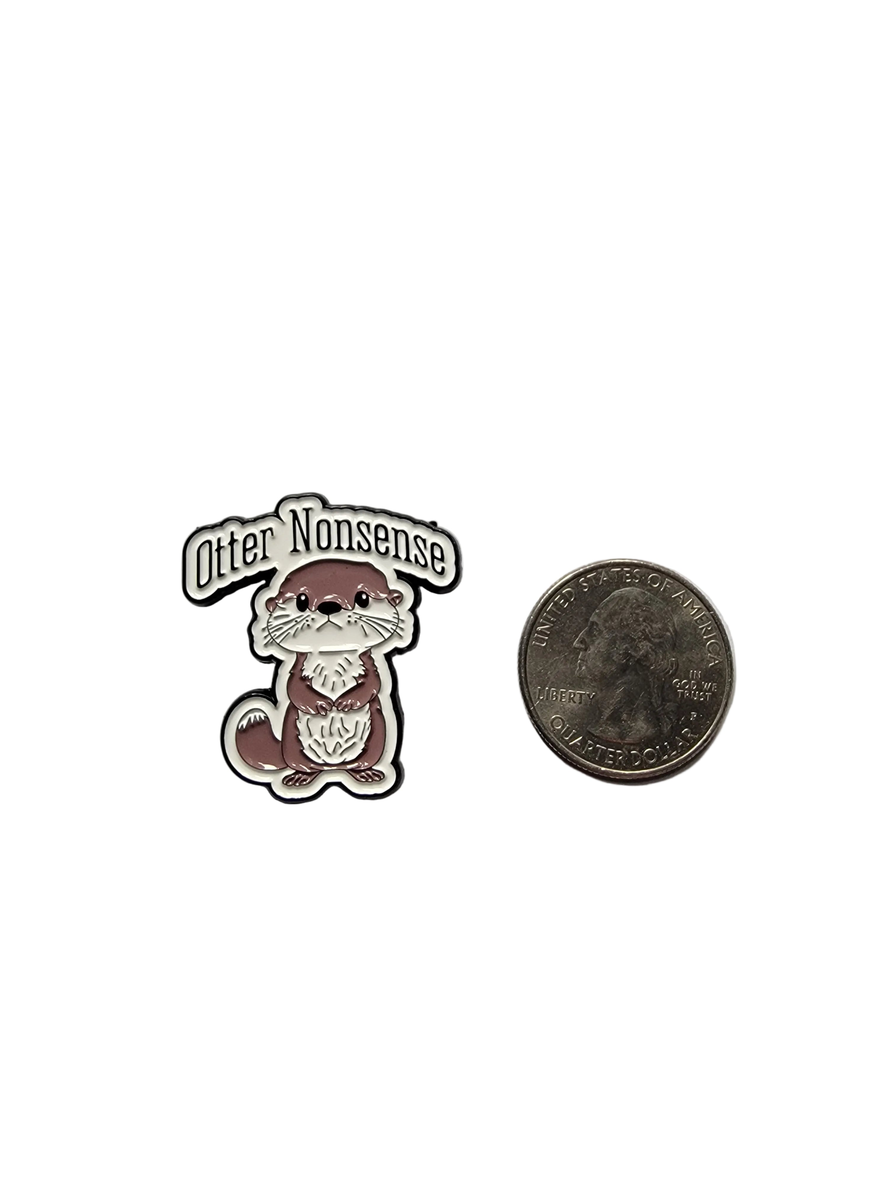 Small enamel pin of a otter with text on a gray background, next to a quarter for scale.