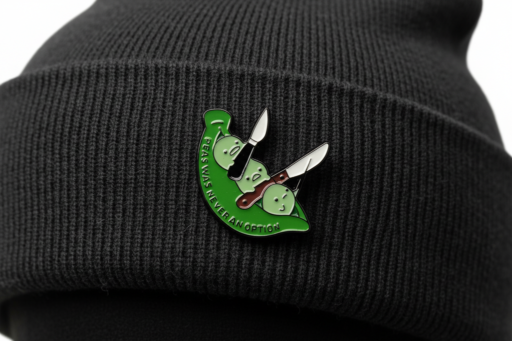 Green and white pin with text on a black beanie background