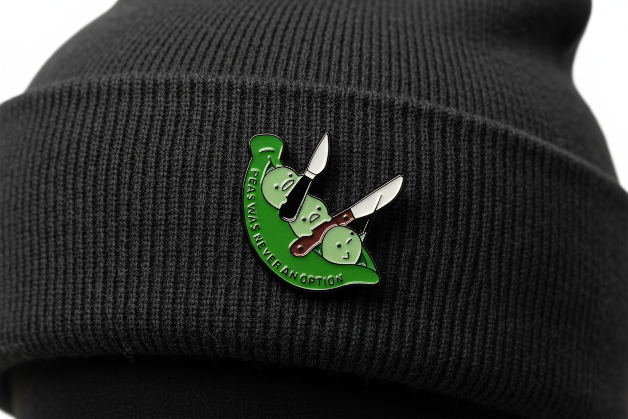 Green and white pin with text on a black beanie background