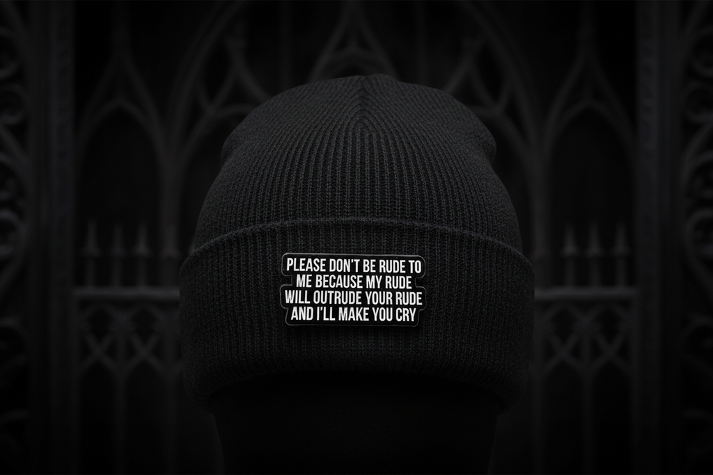 Black metal badge with white text on a black beanie background
